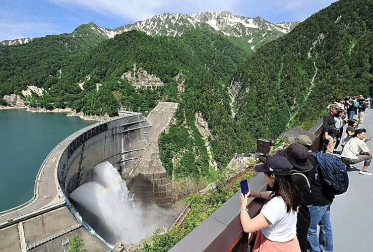 すがすがしい青空が広がり、大勢の人たちが観光放水の迫力を楽しんだ＝２６日午前９時５７分、富山県立山町