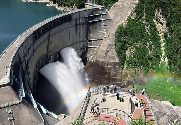 黒部ダムで始まった観光放水。豪快に流れ落ちる水に虹がかかる様子を大勢の人が楽しんだ＝２６日午前１０時３３分、富山県立山町