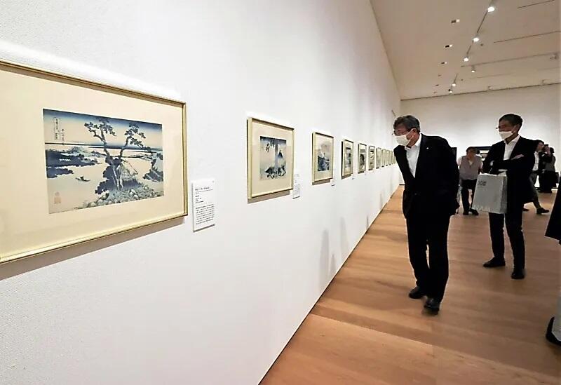 諏訪湖を描いた作品（左端）など「富嶽三十六景」を見て回る内覧会参加者たち＝３０日、長野市の県立美術館