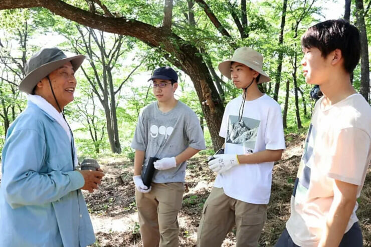 小山さん（左）から霞城についての説明を聞く高校生たち
