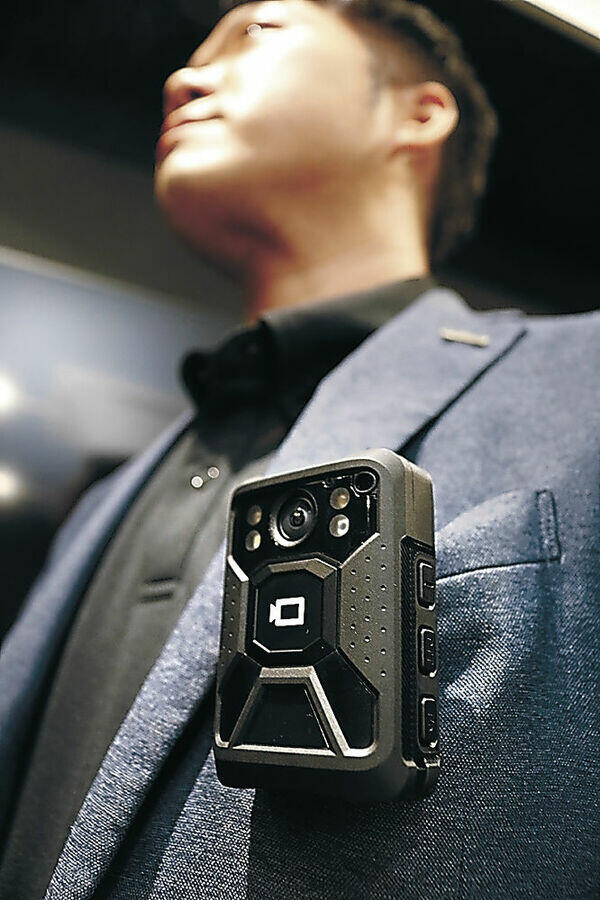 警備員が取り付ける小型カメラ。撮影した映像からＡＩが不審者を検知する