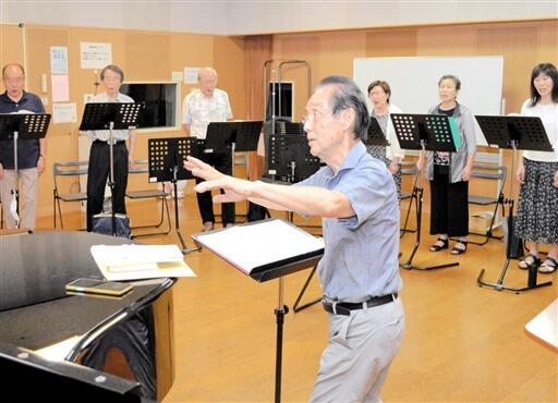 松村さん（中央）の指揮に合わせ、合唱の練習に励む団員たち＝９月２日夜、福井県福井市の県立音楽堂