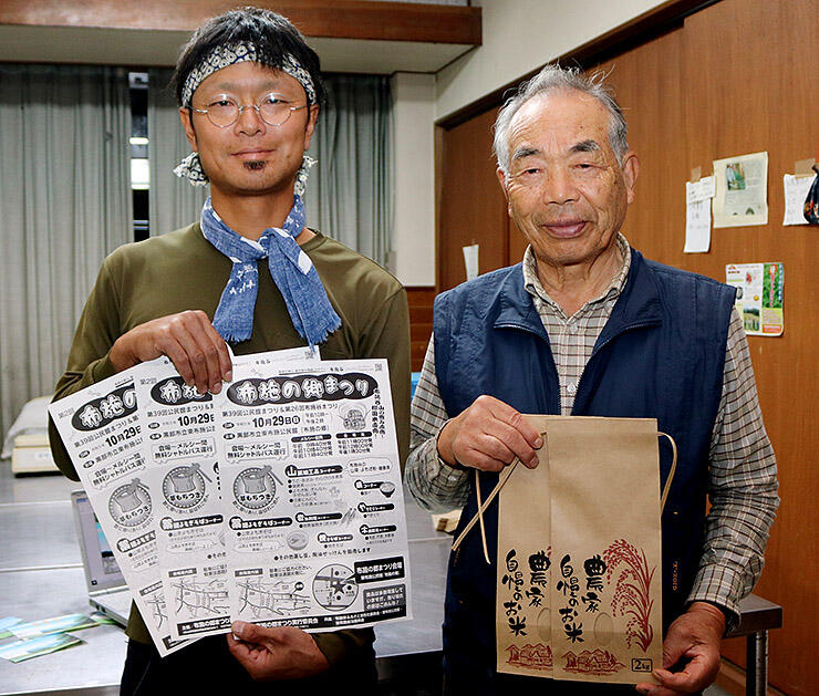 棚田米を入れる袋やチラシを手にＰＲする岩田会長（右）ら