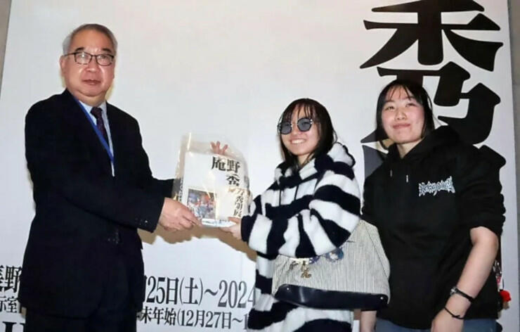 松本館長（左）から記念品を受け取る矢野葵さん（中央）、茜さん
